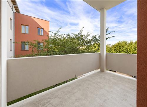 sunlit-balcony-overlooking-trees-and-apartments.png