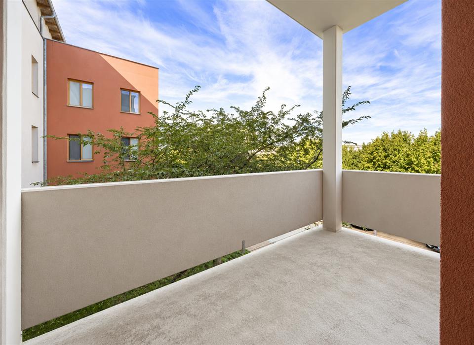 sunlit-balcony-overlooking-trees-and-apartments.png